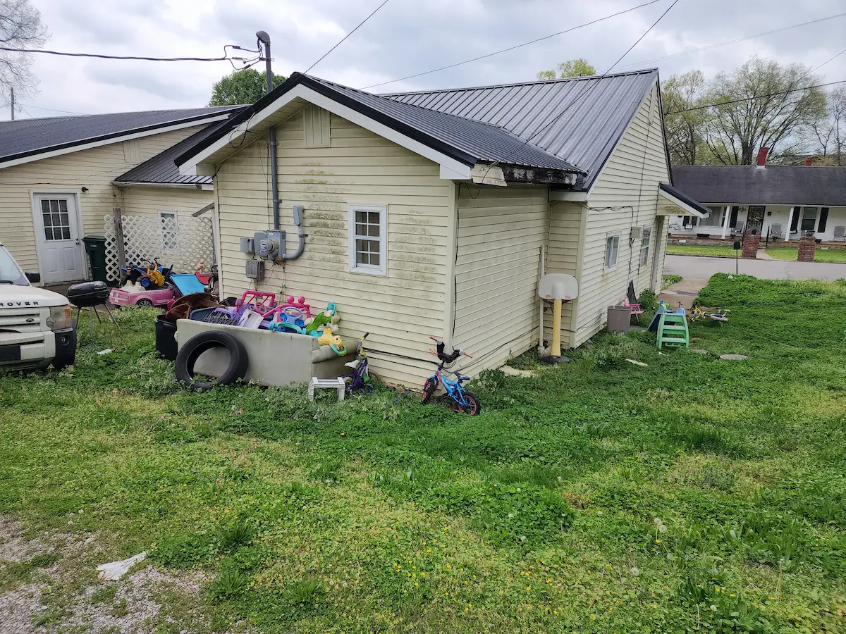 Before photo of a rental property patio cleanup in Pulaski, TN with trash before removal